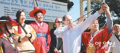 20일 서울 중구 남산 석호정에서 한영 수교 130주년 기념 문화교류 행사에 참석한 스콧 와이트먼 주한 영국대사(가운데)가 연익모 대한국궁문화협회 총재의 도움을 받아 국궁을 체험하고 있다. 이날 영국 홍보대사로 위촉된 배우 채시라 씨(뒷줄 왼쪽에서 두 번째), 박진 전 의원 등이 이 장면을 보며 웃고 있다. 신원건 기자 laputa@donga.com