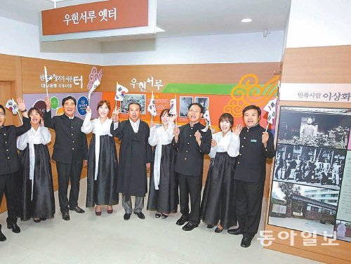 대구 중구 수창동 대구은행 북성로지점에 마련된 우현서루 전시관에서 직원들이 일제강점기 복장으로 태극기를 흔들고 있다. 이 지점은 매주 금요일 이 같은 옷차림으로 근무한다. 1904년 설립된 우현서루는 지역 인재 양성을 위해 한학 등을 가르친 곳이다. 대구은행 제공