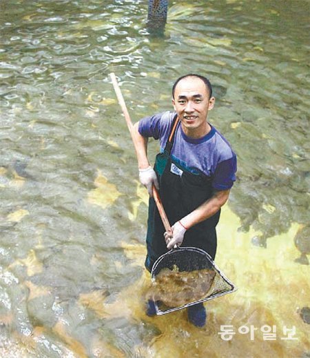 제주 서귀포시 표선면에 있는 바다목장 ‘행복한광어
영어(營漁)조합’ 직원이 지난달 30일 이곳에서 자란
광어를 들어올리며 활짝 웃고 있다. 이마트는 중간
과정을 거치지 않고 이곳에서 광어를 직접 사들여
싼 가격에 판매하고 있다. 이마트 제공