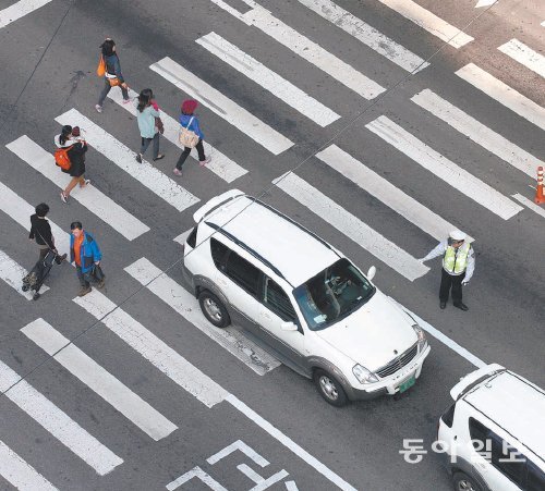 정지선 침범 집중 단속 서울지방경찰청은 1일부터 횡단보도의 정지선을 넘거나 건널목에 정차해 보
행자의 통행을 방해하는 차량을 중점 단속한다. 적색 신호에서 횡단보도의 정지선을 넘어서 정차하면 범칙금
6만 원과 함께 벌점 15점이 부과된다. 교차로 꼬리물기도 범칙금 4만 원이 부과된다. 경찰이 1일 서울 성북구 종암사거리에서 횡단보도를 침범한 차량을 단속하고 있다. 장승윤 기자 tomato99@donga.com