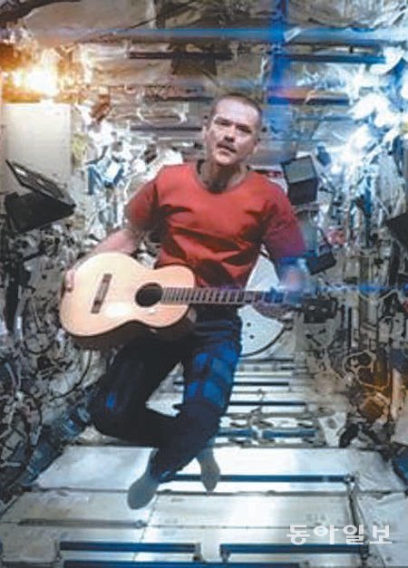 우주비행사 크리스 해드필드가 국제우주정거장에서 직접 기타를 퉁기며 노래를 부르는 모습. 이 동영상은 유튜브에 공개돼 1800만 회가 넘는 조회수를 기록했다. 유튜브 제공