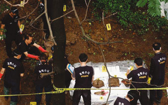 2004년 7월 유영철을 체포한 후 경찰이 그가 사체를 암매장한 서울 봉원사 계곡에서 현장검증을 하고 있다.