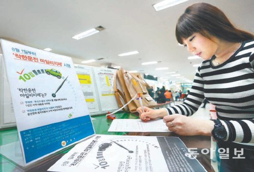 이달 말부터 전국 운전면허시험장에서 ‘착한 운전 마일리지’ 가입이 가능하게 됐다. 시범적으로 서약을 받고 있는
서울 마포구 상암동 서부운전면허시험장에서 6일 정지원 씨가 서약서를 쓰고 있다. 김재명 기자 base@donga.com