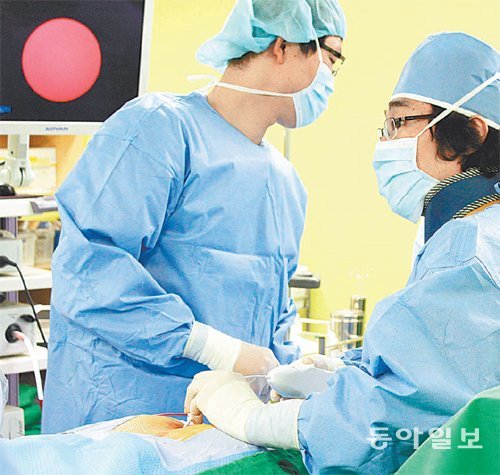 민형식 서울(강동) 튼튼병원장(오른쪽)이 환자의 꼬리뼈 사이로 1㎜ 내시경과 레이저를 집어넣어 미세레이저디스크 시술을 하고 있다. 서울(강동) 튼튼병원 제공