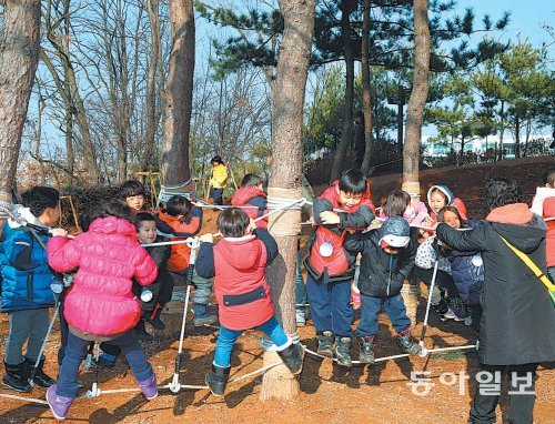 마포대진유치원 어린이들이 서울 마포구 상암산 유아 숲 체험장에서 로프타기 놀이를 하고 있다. 서울 시내 곳곳에는 아이들이 자연스럽게 야외 활동량을 늘리고 계절의 변화를 체험할 수 있는 유아 숲 체험장이 조성 돼 있다. 마포구 제공