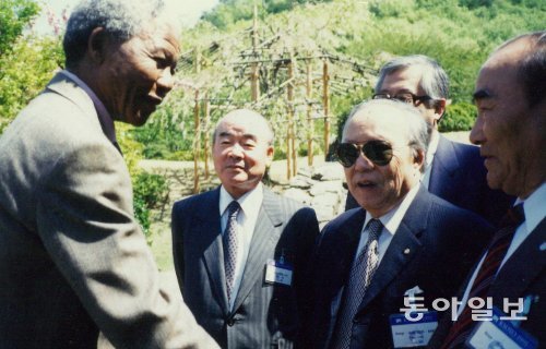 5일 서거한 넬슨 만델라 전 남아프리카공화국 대통령(왼쪽)과 고(故) 일민 김상만 동아일보 명예회장(앞줄 오른쪽에서 두 번째)이 1991년 4월 일본 교토에서 열린 국제신문인협회(IPI) 제40차 연차총회에서 만날 때의 모습. 동아일보DB