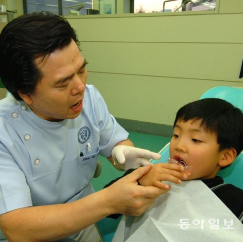 부정교합 치료는 나이가 어릴수록 효과가 높다. 7세 무렵에는 치과 검사를 받아보는 게 좋다. 연세대 치대병원에서 한 전문의가 아이의 턱 교정치료를 하고 있다. 연세대 치대병원 제공
