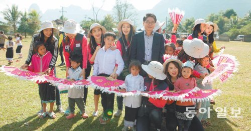 경인여대 류화선 총장(가운데 남자)과 학생들이 20일 라오스 방비엥 나므앙초등학교에 성금을 전달한 후 현지 학생들에게 한국의 부채춤을 소개하고 있다. 경인여대 제공