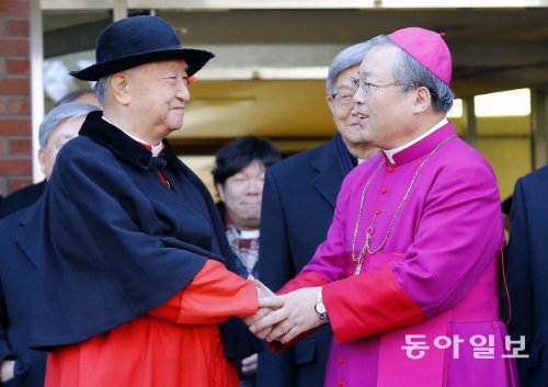 13일 오전 서울 중구 명동 천주교 서울대교구청 앞마당에서 열린 염수정 추기경 임명 축하식에서 정진석 추기경(왼쪽)과 염 추기경이 손을 맞잡으며 기쁨을 나누고 있다. 원대연 기자 yeon72@donga.com