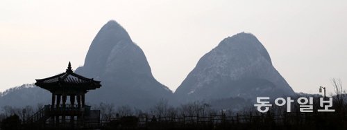 익산∼장수 고속도로 마이산휴게소 옥상에서 바라본 진안 마이산의 숫마이봉(왼쪽 680m)과 암마이봉(686m). 언뜻 눈어림으로는 숫마이봉이 높아보이지만 실제는 암마이봉이 6m 더 높다. 봄엔 돛대봉, 여름엔 용각봉(龍角峰), 가을엔 마이봉(馬耳峰), 겨울엔 문필봉(文筆峰)으로 불린다. 자연이 1억 년 넘도록 빚은 거대한 천연콘크리트 축조물이라 할 수 있다. 기도발이 잘 받는 곳으로 알려져 곳곳에 굿당도 많다. 세계 최고 여행안내서 프랑스 미슐랭그린가이드에서 별 3개 만점을 받았다. 진안 마이산=박경모 전문기자 momo@donga.com