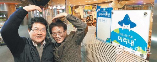 “나누니 행복해요” 21일 ‘미리내 가게’ 활동에 참여한 서울시청 앞 지하도 상가 내 명동칼국수 사장 안현수 씨(왼쪽)와 트리 안 카페 사장 이진영 씨가 가게 앞에서 환하게 웃고 있다. 김재명 기자 base@donga.com