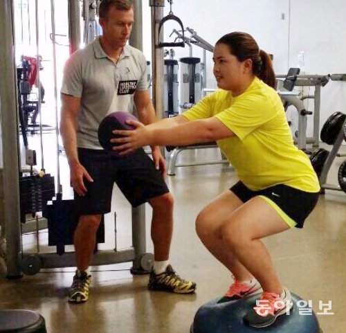 ‘골프 여왕’ 박인비(오른쪽)가 2014 시즌을 대비한 훈련 캠프를 차린 호주 골드코스트의 한 피트니스클럽에서 운동기구인 돔볼을 활용해 근력과 하체 균형감을 키우고 있다. 박인비 제공