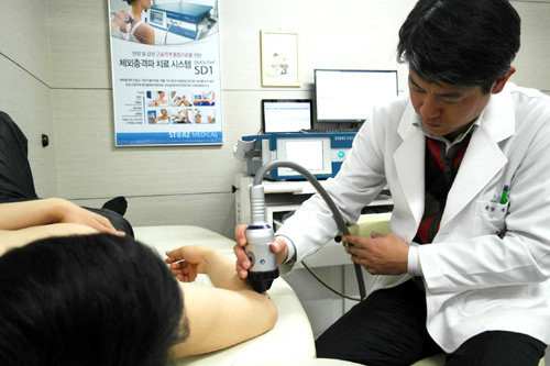 곽봉준 선정형외과 원장(오른쪽)이 만성 어깨통증을 호소하는 환자에게 체외 충격파 치료를 하고 있다. 선정형외과 제공
