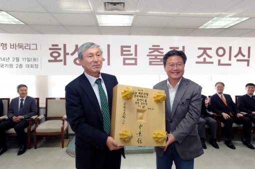 조훈현 한국기원 상임이사(왼쪽)가 채인석 화성시장에게 친필 휘호 바둑판을 증정하고 있다. 한국기원 제공
