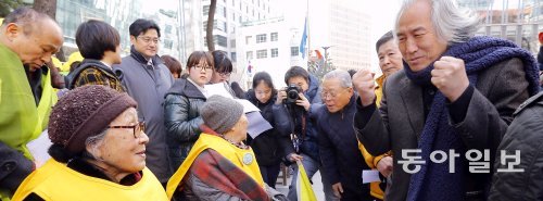 12일 제1113차 일본군 위안부 문제 해결을 위한 정기 수요시위 시작에 앞서 박재동 작가(오른쪽)가 두 손을 불끈 쥐고 김복동 할머니에게 “건강하게 오래 사시라”고 인사하고 있다. 원대연 기자 yeon72@donga.com