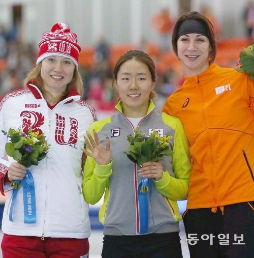 올림픽 2연패에 성공한 뒤 꽃다발을 들고 웃고 있는 이상화(가운데). 소치=변영욱 기자 cut@donga.com