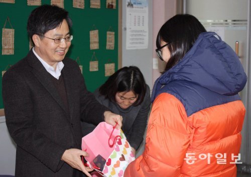 12일 강원 춘천시 동산중을 방문한 김동연 국무조정실장(왼쪽)이 학생들에게 책과 학용품이 담긴 선물을 전달하고 있다. 이인모 기자 imlee@donga.com