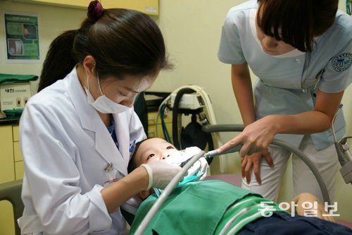 전문가들은 유치 관리에 소홀하면 영구치도 건강하지 못할 가능성이 높아진다고 강조한다. 입학 전 남자 아이가 치아 상태를 검진받고 있다. 한림대의료원 제공