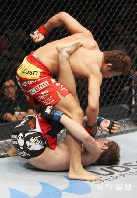 한방에 쓰러진 ‘암살자’ 한국인 1호 UFC 파이터 김동현(위)이 1일 중국 마카오에서 열린 종합격투기 UFC 파이트 나이트 웰터급(77kg) 경기에서 존 해서웨이(영국)의 얼굴에 펀치를 퍼붓고 있다. 수퍼액션 제공