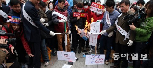 “영업정지 철회하라” 전국이동통신유통협회 회원들이 13일 서울 종로구 보신각 앞에서 ‘영업정지 철폐를 위한 30만 종사자 총결의대회’를 열었다. 참가자들이 ‘영업정지’라고 쓴 종이를 불태우고 있다. 최혁중 기자sajinman@donga.com