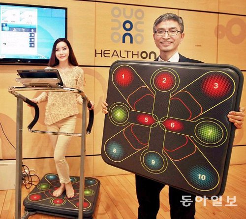 김일겸 허브앤스포크 대표(오른쪽)가 SK텔레콤과 협력해 만든 스마트짐보드를 소개하고 있다. 스마트짐보드는 운동기구 발판에 센서를 설치해 스마트폰, PC용 게임을 발의 움직임으로 조작할 수 있도록 한 운동기구다. SK텔레콤 제공