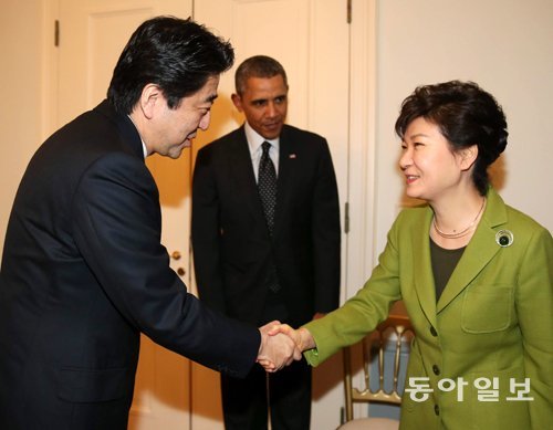 朴대통령, 아베와 악수 한미일 3국 정상이 25일 오후(현지 시간) 네덜란드 헤이그에 있는 미국대사관저에서 만났다. 한일 정상이 한자리에 앉은 것은 2012년 5월 이후 22개월 만이다. 박근혜 대통령(오른쪽)이 아베 신조 일본 총리(왼쪽)와 회담에 앞서 악수를 하고 있다. 가운데는 버락 오바마 미국 대통령. 헤이그=신원건 기자 laputa@donga.com