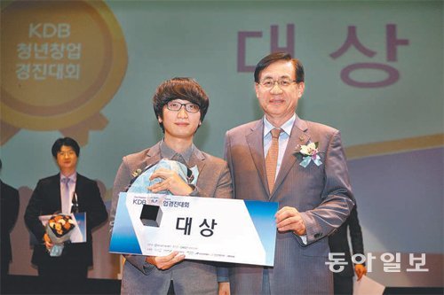 홍기택 산은금융지주 회장 겸 KDB산업은행장(오른쪽)이 지난해 9월 개최한 제1회 KDB창업경진대회에서 대상을 수상한 뱁션 대표 서영화 씨(29)와 나란히 섰다.