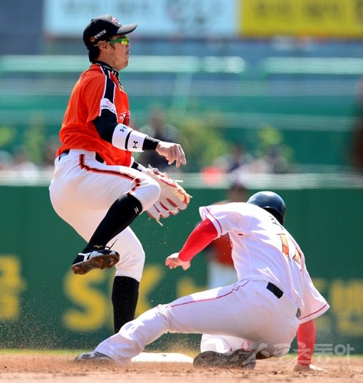 한화 송광민(왼쪽)이 6일 문학 KS전 1회 1사 1·2루서 1루 주자 최정을 2루에서 포스아웃시킨 뒤 1루로 송구하고 있다. 그러나 악송구되며 시즌 6번째 실책을 기록했다. 문학｜김민성 기자 marineboy@donga.com 트위터 @bluemarine007