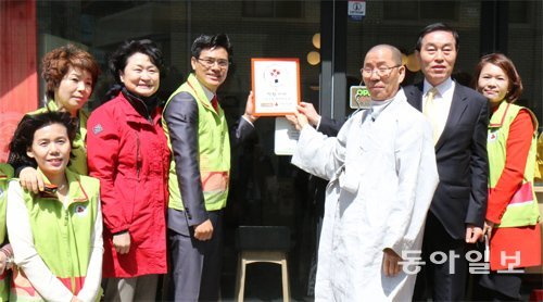 4일 경북 구미시 ‘마을카페 다락’ 입구에서 조중래 구미시 사랑의 열매 나눔봉사단장(왼쪽에서 네 번째)과 법등 스님(왼쪽에서 다섯 번째) 등 참석자들이 착한가게 인증패를 걸고 있다. 경북사회복지공동모금회 제공