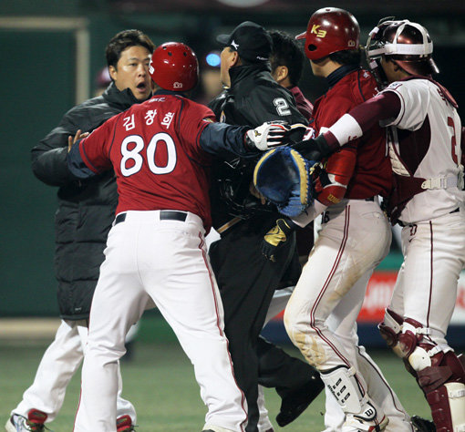 8일 목동구장에서는 9회초 KIA 김주찬이 넥센 투수 손승락의 투구에 맞으면서 벤치클리어링이 일어났다. 넥센 베테랑 투수 송신영(왼쪽)이 흥분하며 그라운드로 달려오는 과정에서 심판과 선수들이 말리고 있다. 양 팀 선수들은 큰 충돌 없이 잠시 후 해산했다. 사진제공｜스포츠코리아