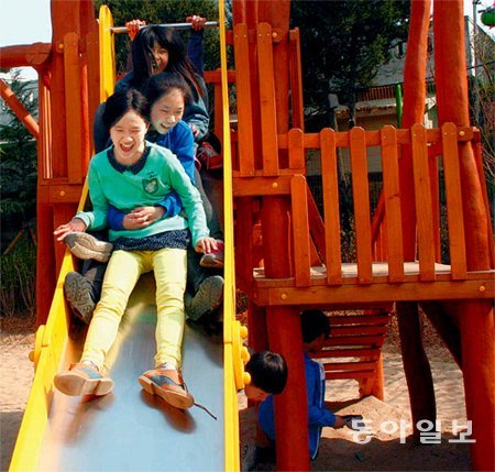 아토피 특성화학교로 변신한 수원 남창초교 운동장에 새로 마련된 친환경 놀이터에서 학생들이 미끄럼틀을 타며 놀고 있다. 남경현 기자 bibulus@donga.com