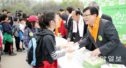 16일 서울 남산골 한옥마을에서 열린 ‘바른 밥상, 밝은 100세 캠페인’의 발대식이 끝난 뒤 이동필 농림축산식품부 장관(오른쪽)이 학생들에게 ‘바른 도시락’을 나눠주고 있다. 신원건 기자 laputa@donga.com