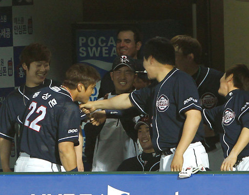 두산의 홍성흔(22번)이 16일 열린 대구 삼성전에서 장원삼을 상대로 연타석 홈런을 때리고 덕아웃에 들어와 동료들의 손에 턱을 대는 익살스런 세리머니를 하고 있다. 사진제공｜스포츠코리아