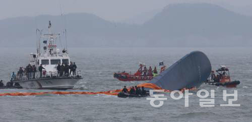 17일 오전 여객선 ‘세월호’가 침몰한 전남 진도군 조도면 병풍도 북쪽 3km 앞 사고 해상에서 해군과 해경이 빗속을 뚫고 수색작업을 벌이고 있다. 진도=홍진환 기자 jean@donga.com