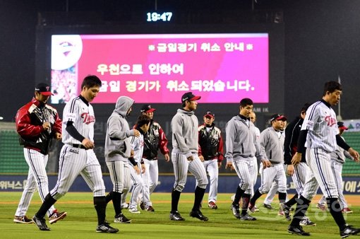 17일 서울 잠실야구장에서 ‘2014 한국야쿠르트 세븐 프로야구’ LG 트윈스와 넥센 히어로즈의 경기가 열렸다. 2회초 무사 1, 2루에서 넥센 공격때 우천으로 경기가 취소되자 LG 선수들이 팬들에게 인사한 뒤 그라운드를 빠져나가고 있다. 잠실｜김민성 기자 marineboy@donga.com 트위터 @bluemarine007