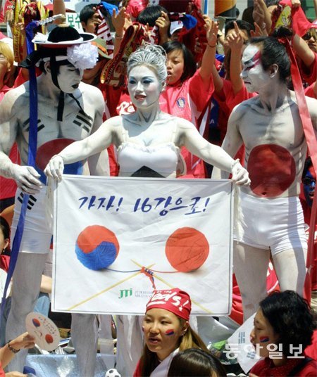2002년 한일 월드컵 공동개최 당시 태극기와 일장기로 보디페인팅을 한 모델들이 서울 광화문에서 붉은 악마의 환호 속에 한일 양국의 16강 공동 진출을 기원하는 퍼포먼스를 펼치고 있다. 동아일보DB