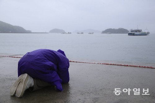 비 내리는 전남 진도 팽목항에서 바다를 향해 엎드린채 기도하고 있는 실종자 가족. 동아일보DB