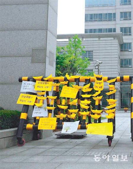 8일 인천 연수구 해양경찰청 정문 앞 바리케이드에 한 시민단체가 해경 수사를 촉구하는 의미로 노란색 종이배를 붙여 놨다.