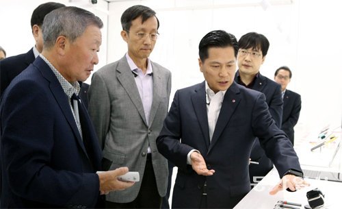구본무 LG그룹 회장(왼쪽)이 21일 서울 금천구 가산동의 LG전자 가산 연구개발(R&D) 캠퍼스에서 조만간 출시될 ‘G3’(스마트폰)와 ‘G워치’(웨어러블 기기)의 기능과 디자인 특징에 대한 설명을 듣고 있다. LG그룹 제공