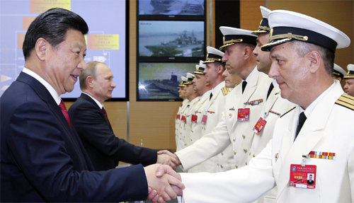 상하이의 두 정상 시진핑 중국 국가주석(왼쪽)과 블라디미르  푸틴 러시아 대통령(왼쪽에서 두 번째)이 20일 상하이 우쑹 군항에서 열린 중-러 연합해상훈련 개막식에 참석해 러시아 해군 장병들과 악수하며 그들을 격려하고 있다. 상하이=신화 뉴시스