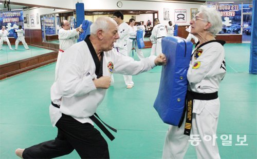 지난달 14일 미국 로드아일랜드 주 홍진섭 사범의 태권도장에서 전직 대학교수 루이스 알폰소 씨(왼쪽)가 보호대를 들고 있는 치의학
 박사 퍼렐 모턴 씨를 상대로 정권 지르기 연습을 하고 있다. 79세 동갑인 두 노인은 각각 전립샘암과 심근경색을 앓았지만 수술을
 마친 뒤 지속적인 태권도 수련으로 건강을 회복했다. 로드아일랜드 버지니아=신석호 특파원 kyle@donga.com