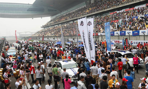 25일 열린 슈퍼레이스와 차이나 투어링카 챔피언십을 보기 위해 중국 상하이 인터내셔널서킷을 찾은 관중이 개막식에 앞서 트랙에 내려와 경기에 출전하는 자동차들을 살펴보고 있다. 슈퍼레이스 제공