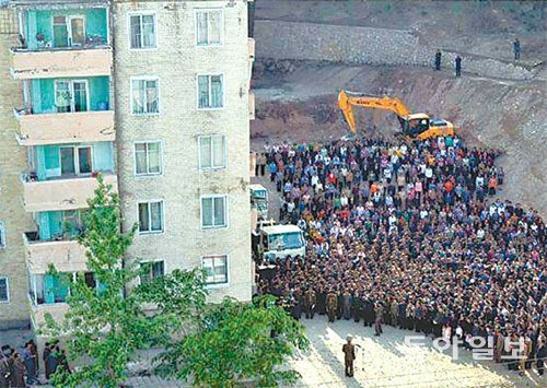 17일 북한 당국자들이 희생자 유족에게 사과하는 모습. 붕괴된 아파트는 여기서 약 30m 떨어져있다. 사진 출처 노동신문 홈페이지