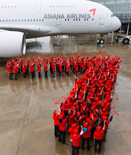 에어버스 직원들, 날개모양 만들어 축하 아시아나항공이 26일 프랑스 툴루즈의 에어버스 본사 항공기 인도센터에서 A380 1호기 인수 행사를 할 때 빨간 티셔츠를 입은 에어버스 직원들이 아시아나항공의 상징인 윙(Wing) 로고 모양으로 줄지어 서서 축하하고 있다. 아시아나항공 제공