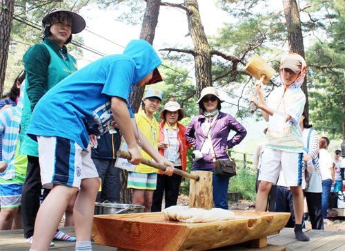 ‘2014 하이원 에코투어’ 참가자들이 1일 정선 개미들마을 낙동계곡에서 떡메치기를 하며 즐거워하고 있다. 개미들마을 제공