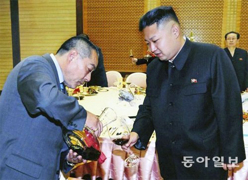 2012년 7월 북한을 방문한 김정일의 전 요리사 후지모토 겐지 씨가 김정은에게 와인을 따르고 있다.