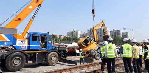 한국철도시설공단 직원들이 5월 30일 대전 대덕구 대전조차장에서 대형사고 대응훈련의 일환으로 지진이 났을 때를 가정해 철도 건설장비를 크레인으로 들어올리는 모의 훈련을 하고 있다. 한국철도시설공단 제공