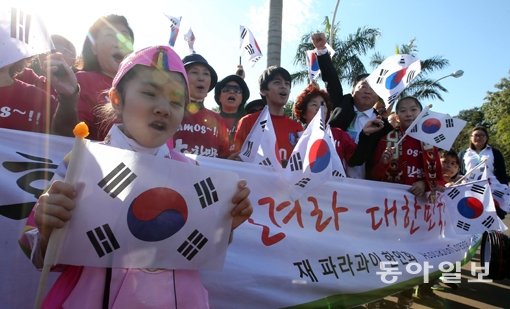 파라과이 교민들이 11일(한국시간) 축구대표팀의 브라질월드컵 베이스캠프인 이구아수 버번리조트 앞에서 태극기를 들고 응원전을 펼치며 선수단의 도착을 기다리고 있다. 이구아수는 브라질, 파라과이, 아르헨티나의 접경지대에 있다. 이구아수(브라질)｜양회성 동아일보 기자 yohan@donga.com