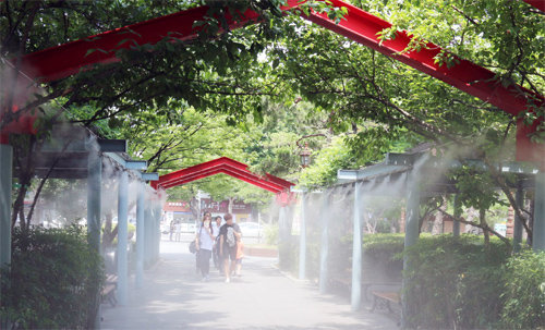 18일 대구 국채보상운동기념공원에 설치된 쿨링 포그 통로를 청소년들이 지나가고 있다. 대구시 제공