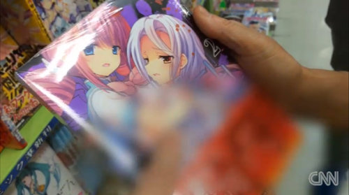 일본 도쿄 아키하바라의 한 만화책 상점에 진열된 성인용 잡지의 표지. 어른인지 청소년인지 알 수 없는 외모의 여성 캐릭터가 야릇한 표정을 짓고 있다. CNN 화면 캡처